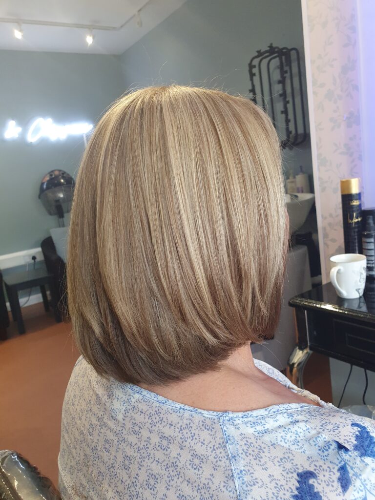 Medium length layered women’s haircut at Snippers and Clippers